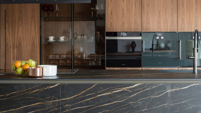 Copper Shell House, kitchen countertop and island in Bianco Statuario Venato - I Naturali series; Private residence in Naples. Kitchen countertop, drawer fronts, drawers, storage, sink and hood in Noir Desir - I Naturali series